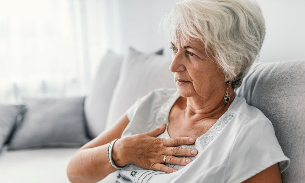 an elderly woman experiencing heartburn